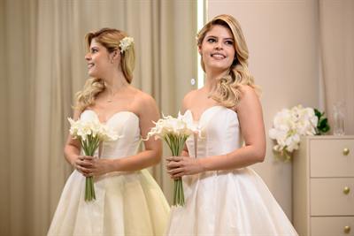 Duas noivas prontas, com penteados e buquês